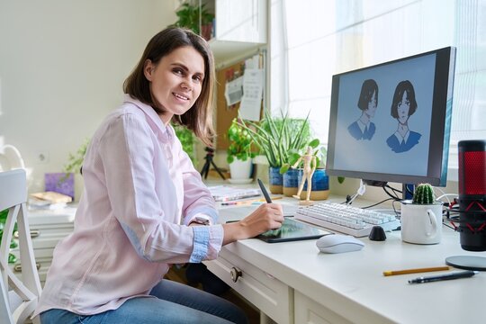 Portrait of young woman designer looking at camera, female with graphic tablet