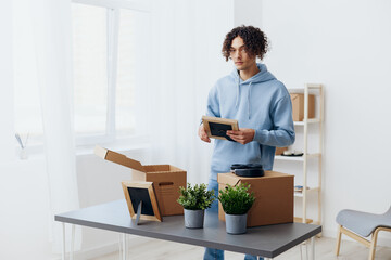 A young man unpacking things from boxes in the room Lifestyle