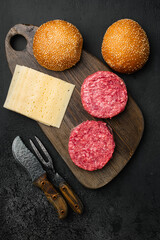 Raw Ground beef meat Burger patties on black dark stone table background, top view flat lay