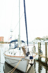 A white yacht sailboat is docked at a pier marina in Florida. 
