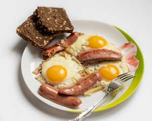 fried eggs on a white plate with bread with seeds.