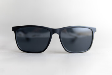 black sun glasses on gray background front view