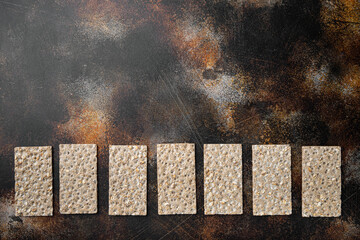 Thin rye crispy cracker, on old dark rustic table background, top view flat lay, with copy space...