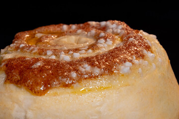 Cinnamon bun baking and rising on tray in electric oven - close up view. Swedish cuisine, homemade bakery, food, cooking and pastry concept