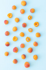 Delicious ripe sweet apricots on blue background, flat lay. Space for text