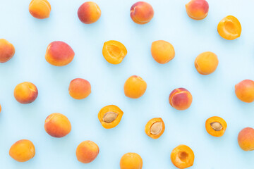 Delicious ripe sweet apricots on blue background, flat lay. Space for text