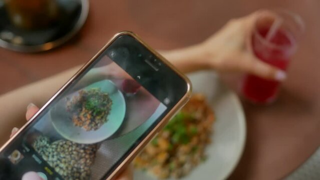 Women's hands take pictures of food for dinner using a smartphone. Close-up. 4K.