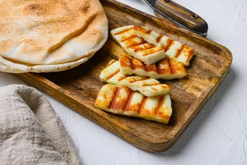 Gordijnen Traditinal Cypriot Halloumi Cheese, on white stone table background © Ilia Nesolenyi