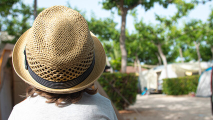 Boy with yellow straw hat on vacation at a campsite