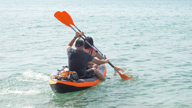 couple in kayak paddling and sailing in the blue sea