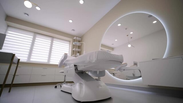 Beauty and body care. Interior of new beauty salon with spa massage table and set of skincare products ready for use. Empty professional dermatologist room waiting for customers