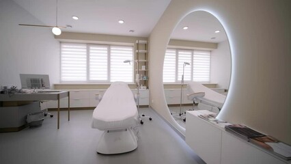 Beauty and body care. Interior of new beauty salon with spa massage table and set of skincare products ready for use. Empty professional dermatologist room waiting for customers