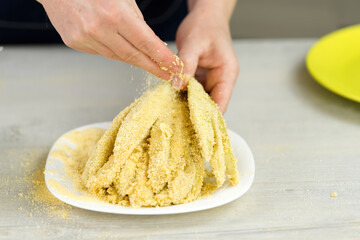 Coating sliced eggplant with breadcrumbs. Woman is cooking tasty snacks at home. close up