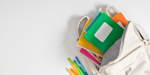 Backpack with colorful school supplies on white background. Back to school. Flat lay, top view, copy space - obrazy, fototapety, plakaty