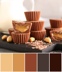 Board with tasty peanut butter cups on table. Different color patterns
