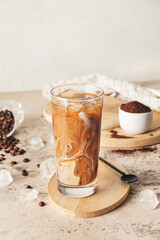 Wooden board with glass of delicious cold brew coffee and milk on grunge table