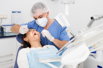 Portret of male dentist and woman patient sitting in medical chair during checkup at dental clinic...
