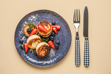 Delicious cottage cheese pancakes with berries served on beige background