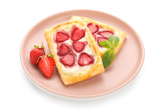 Plate with strawberry puff pastries and mint leaves on white background