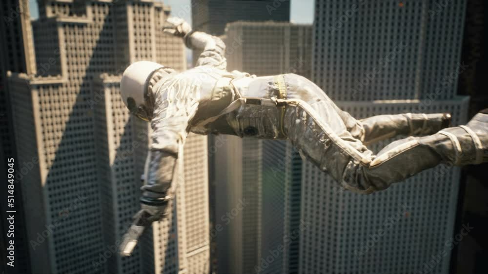 Wall mural astronaut traveler flying past skyscrapers. astronaut's fall from space to the planet. the flight of
