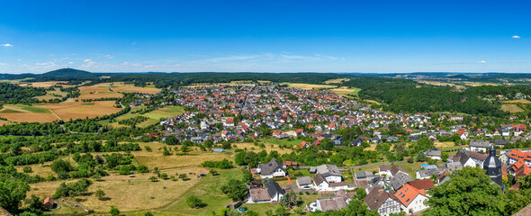 Übersicht über die mittelhessische Gemeinde Krofdorf-Gleiberg in einer Panoramaaufnahme bei sonnigem Sommerwetter mit Horizont, wolkenlosem Himmel und  landwirtschaftlich genutzter Umgebung