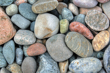 Beach rounded rocks in various colors from ocean