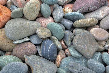 Beach rounded rocks in various colors from ocean