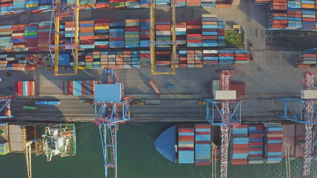 Loading and unloading a container ship in the port at the pier. Aerial view of business logistics import and export cargo transportation by container ship. Containers on a cargo vessel. Time lapse 4K