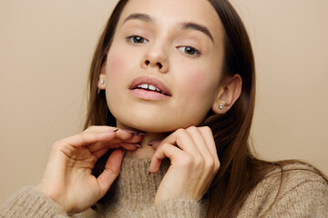 a close, horizontal photo of a beautiful, sophisticated woman straightening her hair by putting her...