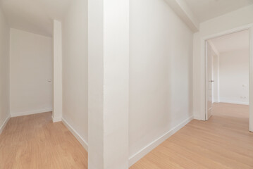 Distributor corridors in an empty house with wooden floors and plain white painted walls