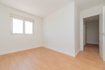 Fototapeta na wymiar Empty room with light wooden floors, freshly painted plain white walls and a white aluminum window