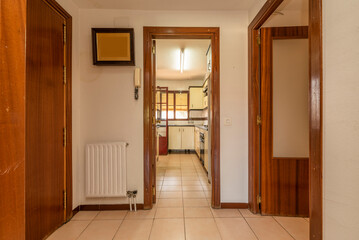 Entrance hall and distributor of a house with cream ceramic stoneware floors, red wood carpentry and entrance to several rooms