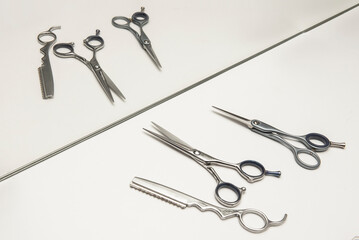 Sharp and clean scissors ready for haircuts in front of a mirror