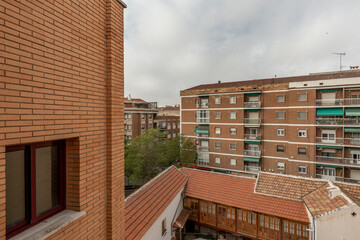 Roofs and facades of a city with clay tiles and bricks of the same material on a cloudy day