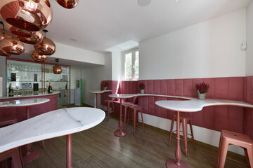 Designer dining room in a restaurant with pink furniture and white marble