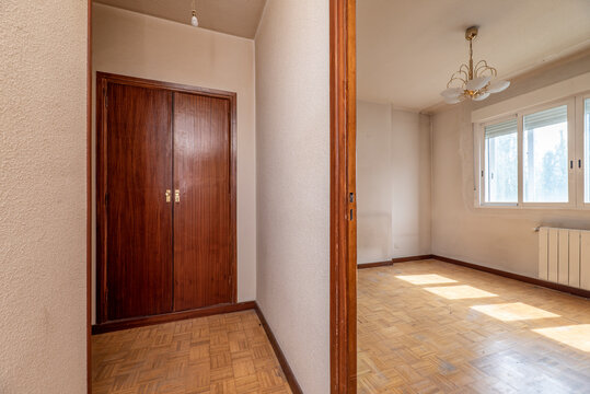 Distributor of a house with worn oak parquet floors, aluminum windows and built-in wardrobe with wooden doors