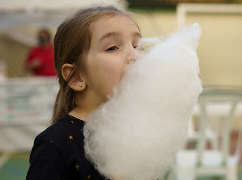 menina se deliciando com algod&atilde;o doce 