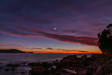 First light over the ocean with 9 percent sliver of moon and stars