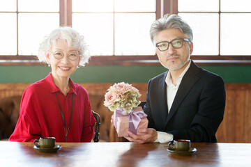 花束をプレゼントする中高年の夫婦