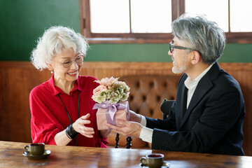 花束をプレゼントする中高年の夫婦