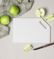 Pieces of ripe green apple on white marble board on kitchen table, top view flat lay mockup