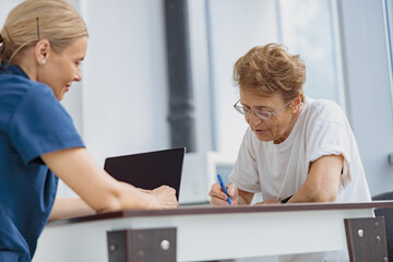 Obraz premium Female patient signing treatment agreement in doctor's office in clinic. High quality photo