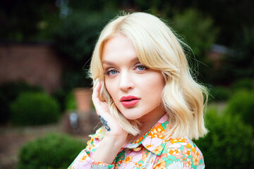 Portrait of a Woman with long blond hair wearing a floral top 