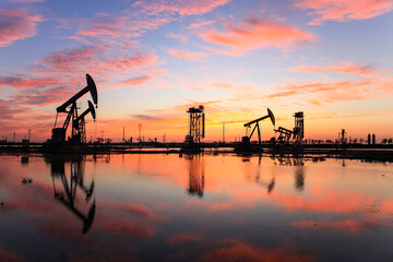 in the evening, oil pumps are running, The oil pump and the beautiful sunset reflected in the...