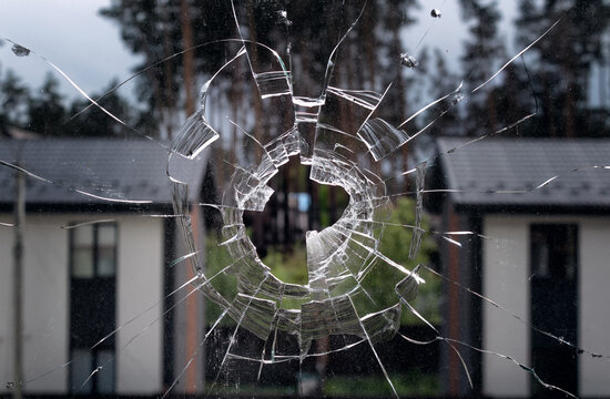 Broken window glass on a background houses. Texture of broken glass.