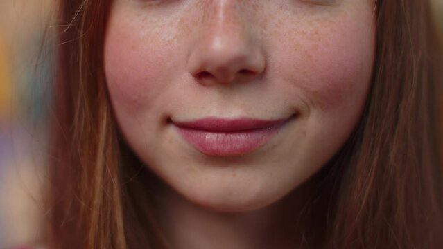 Portrait close-up of young happy redhead woman smile braces mouth, charming lovely ginger teen girl with white great healthy teeth close up. Pink lipstick. Female freckles model smiles wide for camera