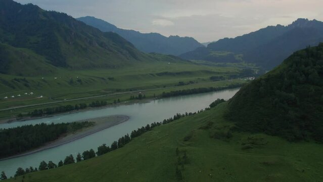 Katun river and mountains of Altai valley at sunset time, Siberia, Russia. Beautiful summer nature landscape at during evening time. Aerial view from a drone