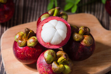 Fresh Mangosteen fruit and half mangosteen on wooden table