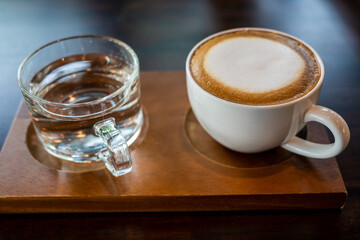 White hot latte cups and drink glasses on wooden tray
