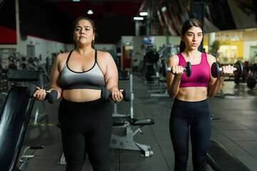 Strong fit coach and overweight woman exercising